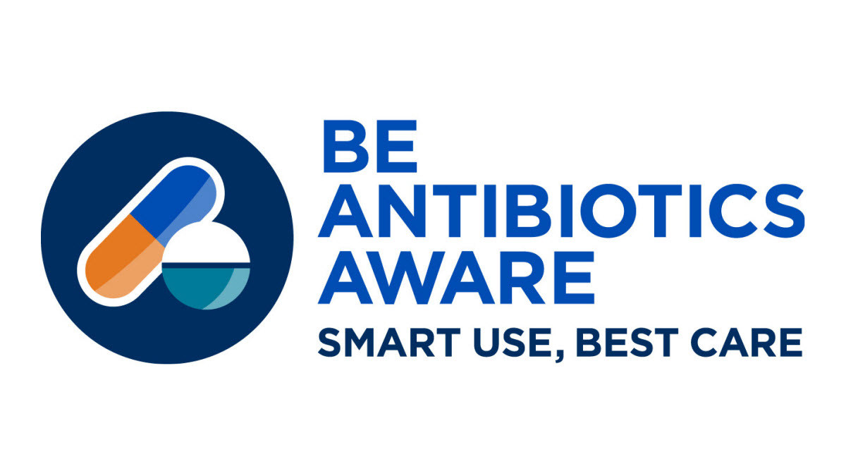 Image includes large dark blue circle with blue and orange pill, and white and blue tablet inside. &ldquo;Be Antibiotics Aware: Smart Use, Best Care&rdquo; written to the right of image in blue.