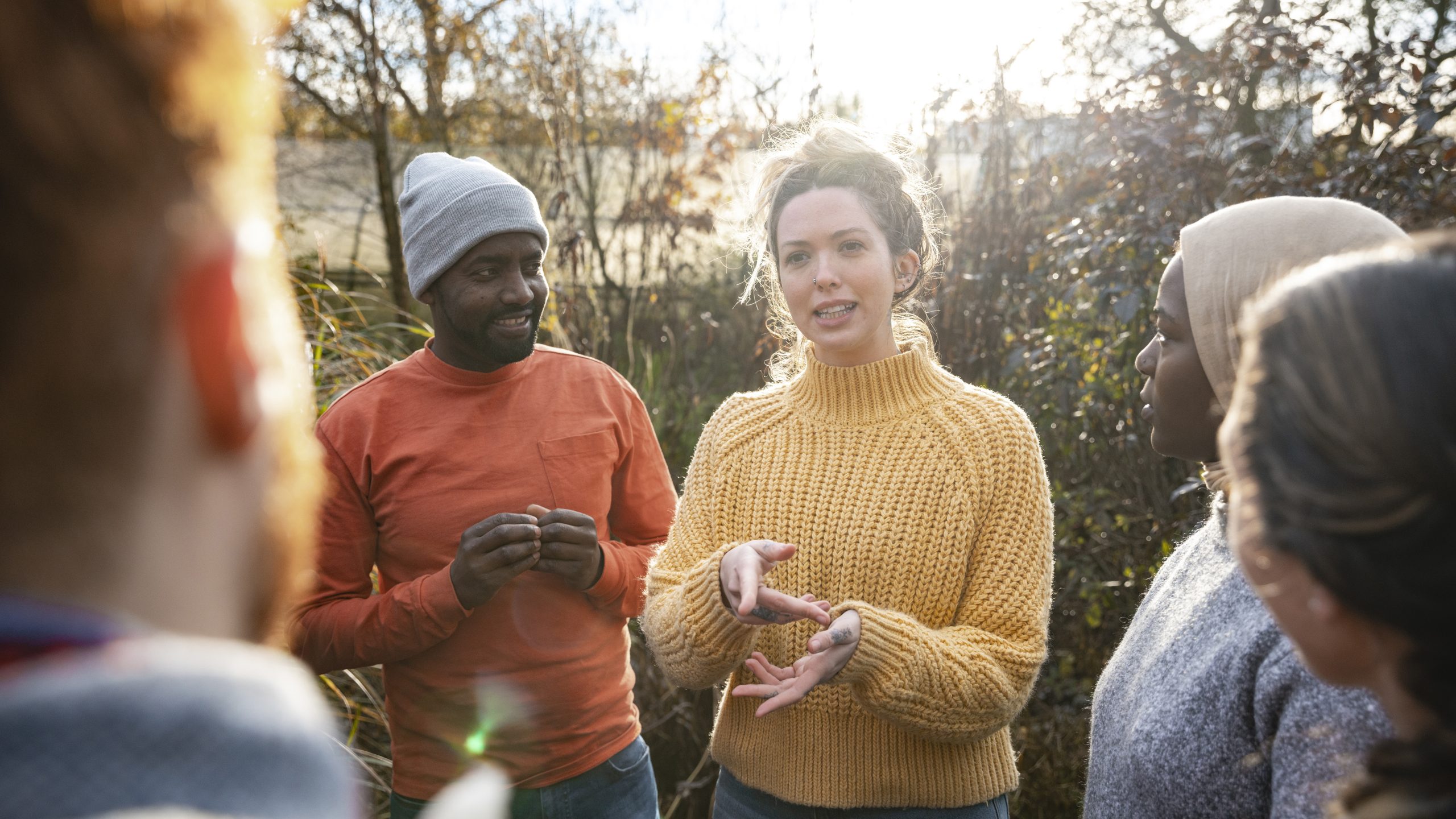 Behavioral Sciences A woman talks to a diverse group of volunteers outdoors