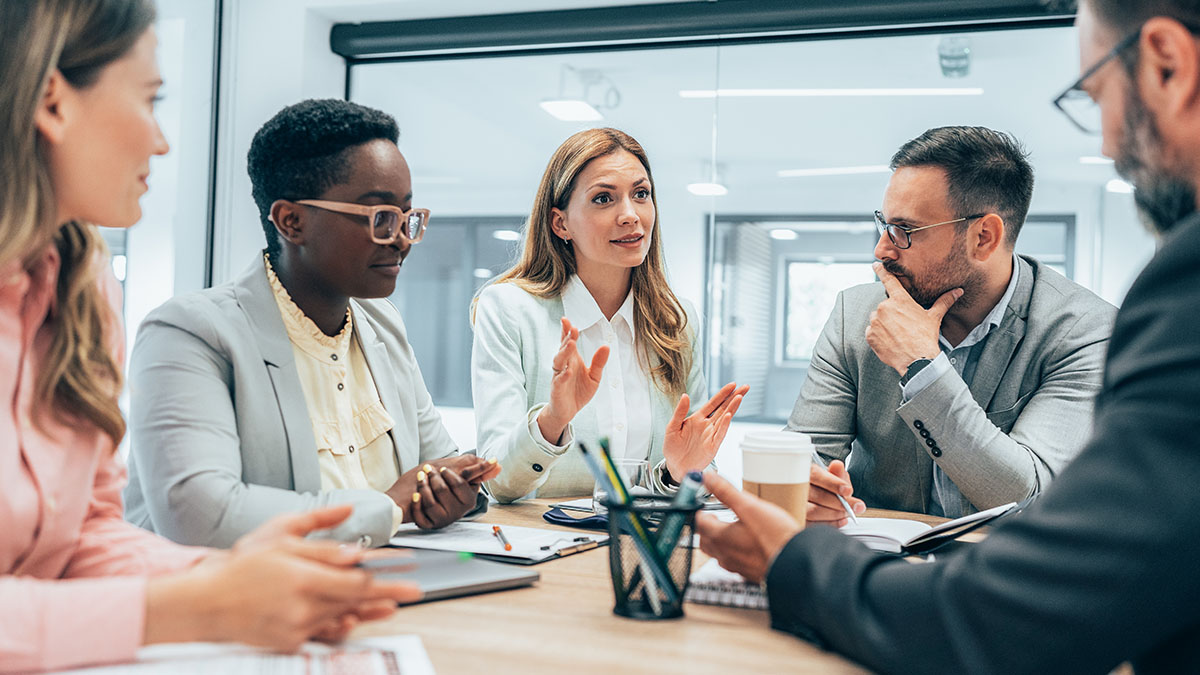 health professionals Five people at an office table talking