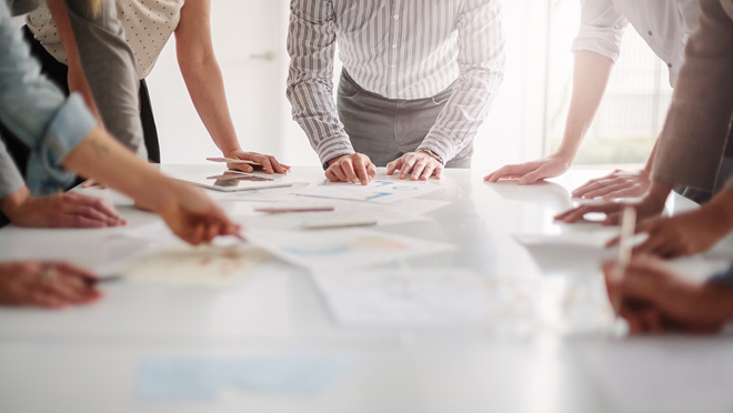 CDC Budget Operating Plans View of hands of multiracial group of people working with ideas together to make decisions with documents on table.