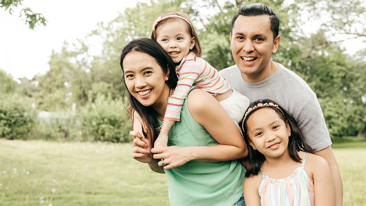 risk-home Husband and wife with their two young daughters.